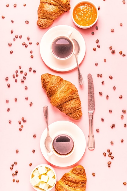 Coffee and croissants on pastel background