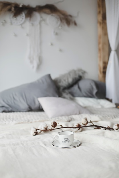 사진 커피 컵과 목화 꽃. 침대에서 아침 식사.