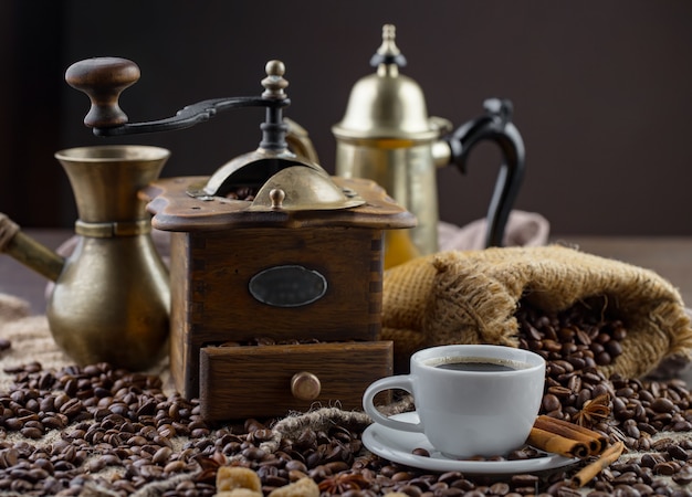 古い背景の上のコーヒー豆の背景の上にカップのコーヒー