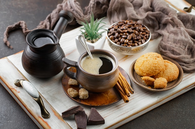 古い背景の上のコーヒー豆の背景の上にカップのコーヒー