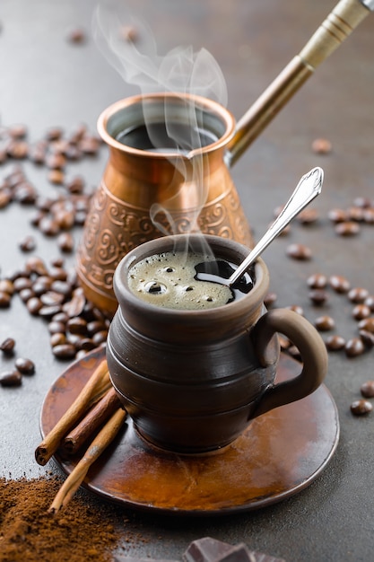 古い背景の上のコーヒー豆の背景の上にカップのコーヒー