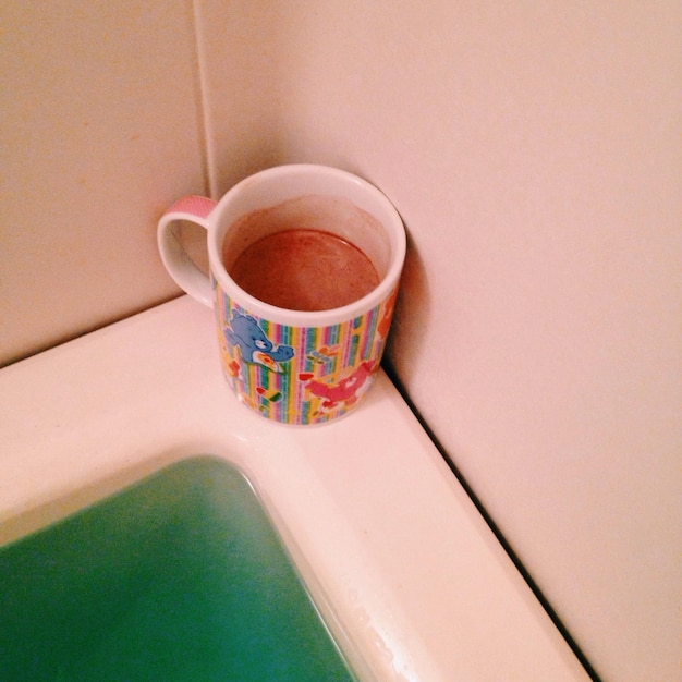 Photo coffee cup on bathtub corner