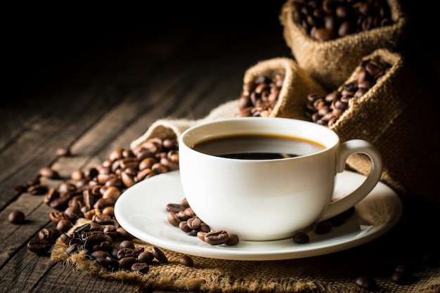 Coffee cup and beans. Coffee Espresso and a piece of cake with a curl. Cup of Coffee and coffee beans on table.