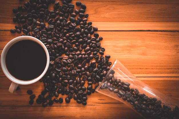 Coffee cup and beans on old kitchen table 