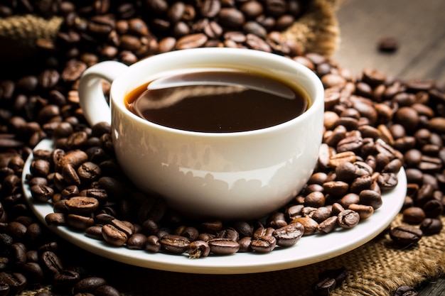 Coffee cup and beans on a rustic background.  