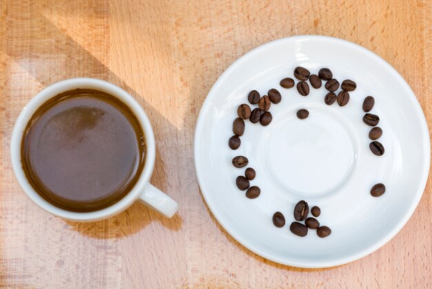 Coffee cup and beans on wooden background