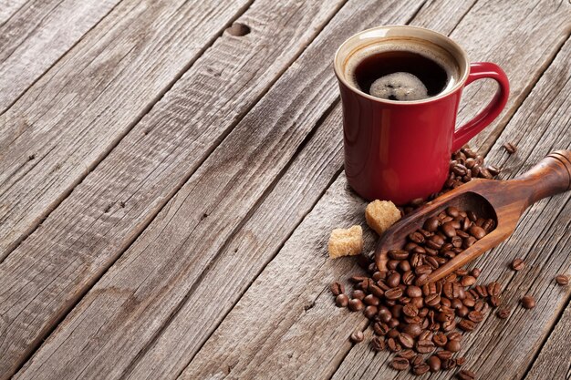 Coffee cup and beans on wooden table