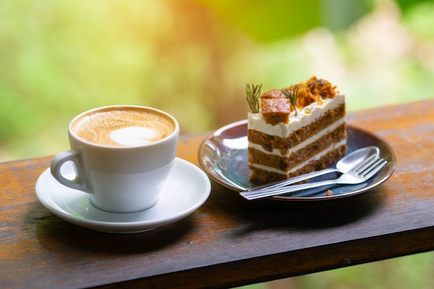 木のテーブルの上のコーヒーカップとケーキ