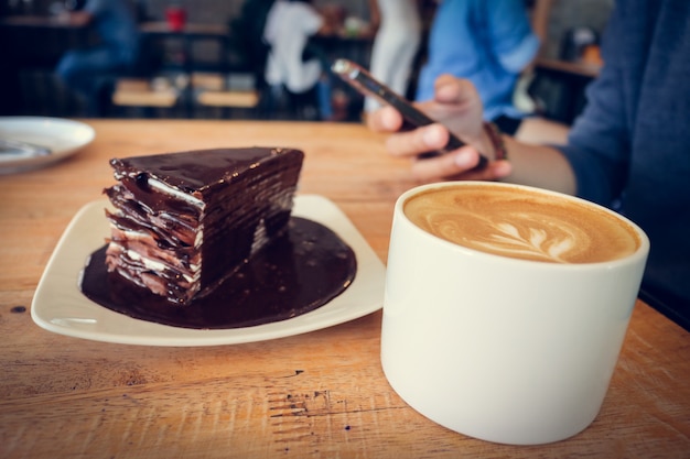 木製テーブルにコーヒーカップとチョコレートケーキ