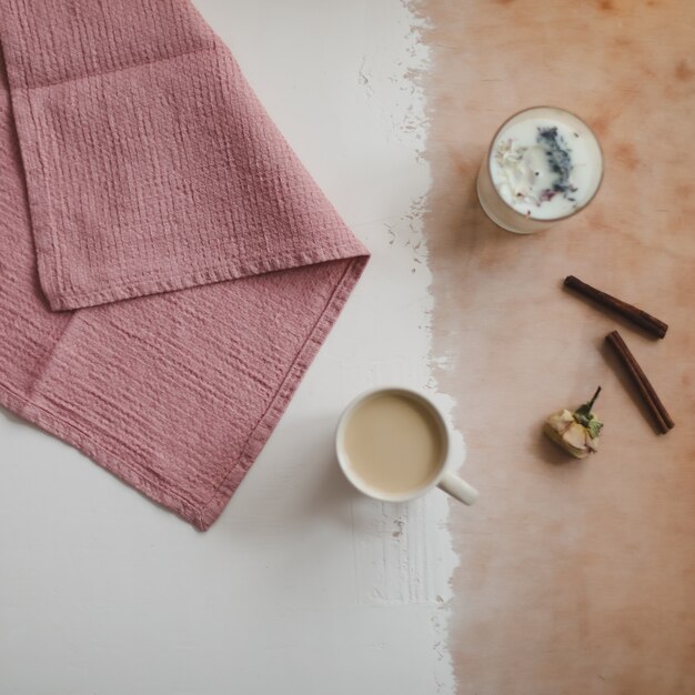 Coffee cup cinnamon and napkins on white rustic wooden surface