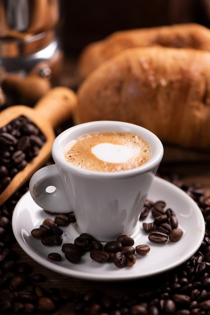 Coffee cup close-up over dark roasted coffee beans