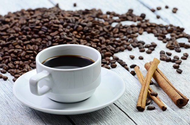 Tazza di caffè e chicchi di caffè in giro