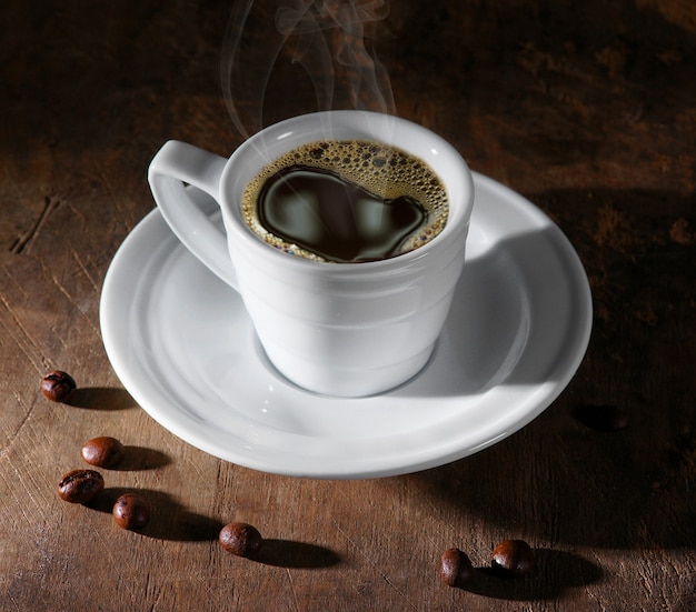 Coffee cup and coffee beans on dark background