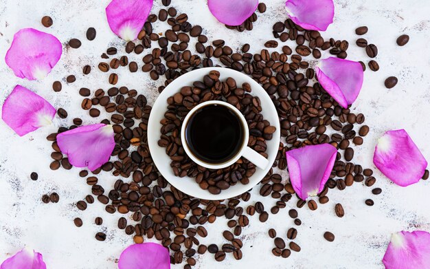 Coffee cup, coffee beans and rose petals. Top view. Flat lay