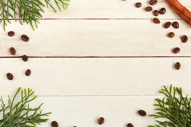 Coffee Cup, coffee beans and spruce branches on wooden background.