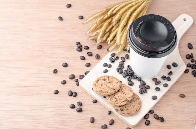 Photo coffee cup and coffee beans on wooden background