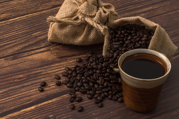 Coffee cup and coffee beans on wooden table