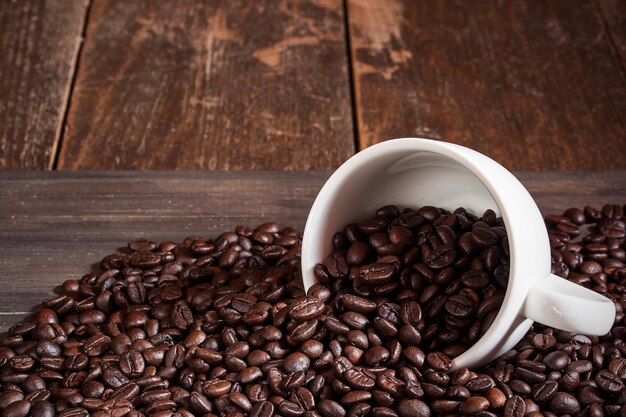 Coffee cup and coffee beans on wooden table