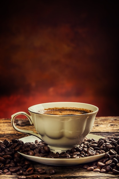 Coffee. Cup of coffee and coffee beans. Vintage cup and old oak table.