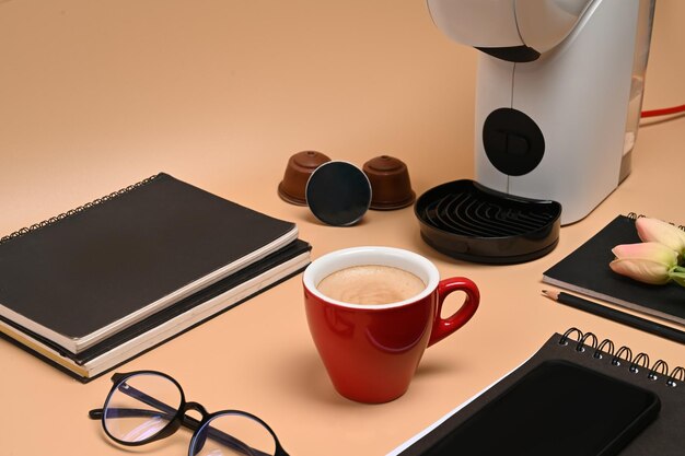 Coffee cup and coffee machine on beige background