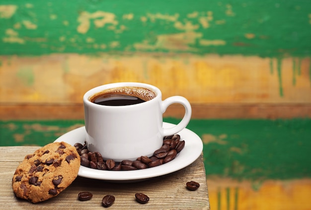 Coffee cup and cookies on vintage wooden background