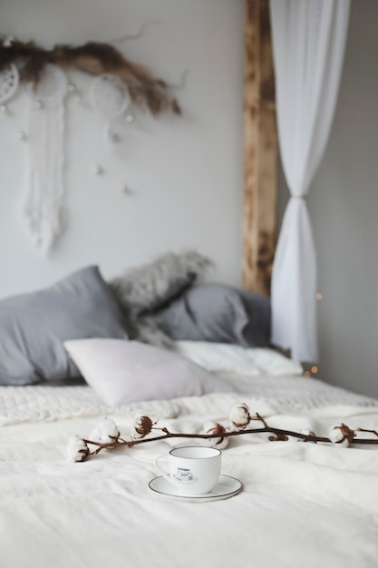 Coffee cup and cotton flower. Breakfast in bed.