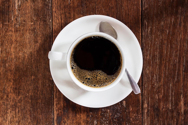 暗い木製のテーブルの上のコーヒーカップ