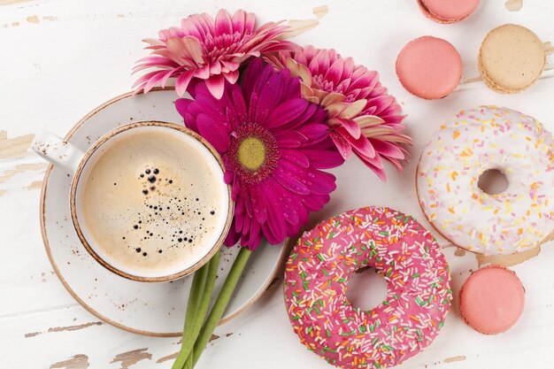 Coffee cup donuts and gerbera flowers