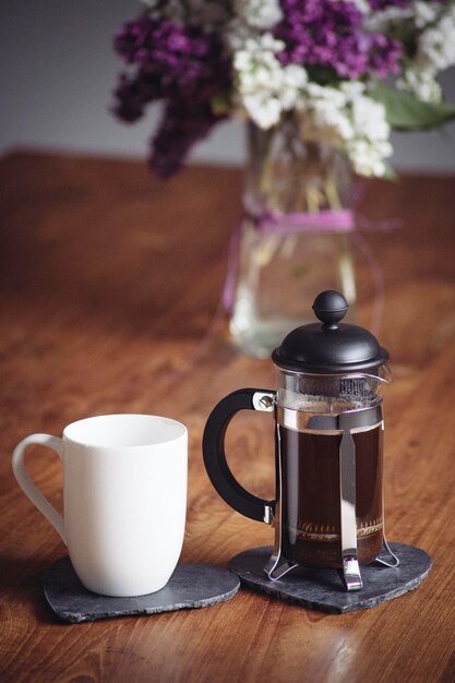 Photo coffee cup and french press on table