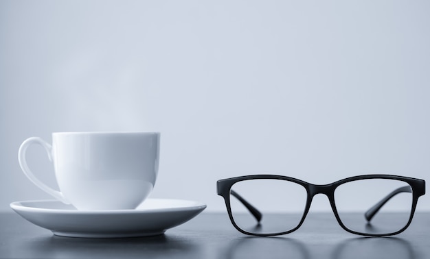 Coffee cup and glasses on desk