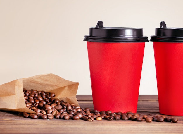 Coffee cup to go and bag with beans at wooden table