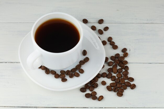 Caffè in una tazza e grani sul tavolo