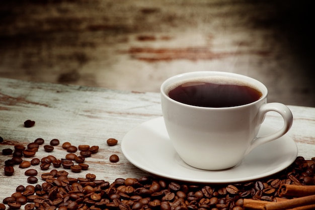 Coffee cup over grunge wooden background