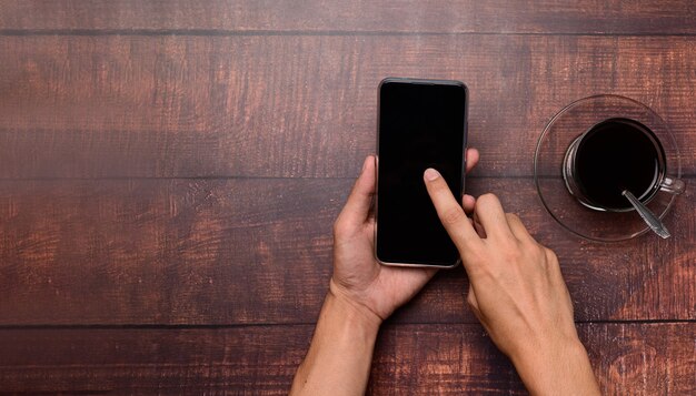 Coffee cup, hand holding and using smartphone