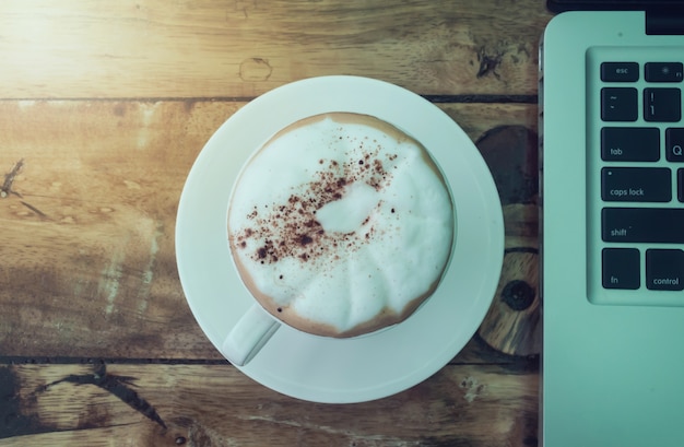 Coffee cup and laptop for business in coffee shop