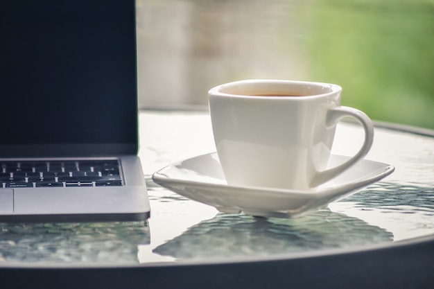 Coffee cup and laptop put on the table