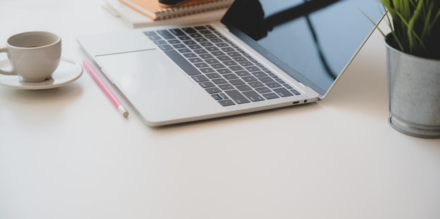 Coffee cup and laptop on table