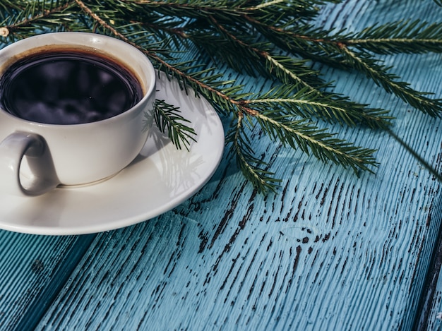 Tazza di caffè sull'albero di abete verde chiaro.