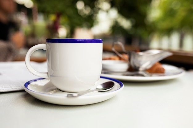 Coffee cup on little plate outdoors