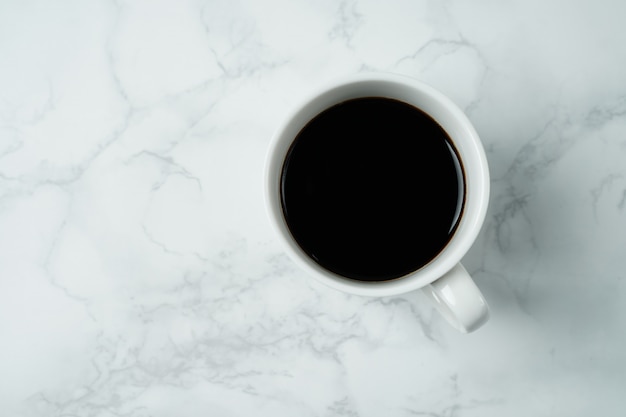 Photo coffee cup on marble texture table, black coffee cup in top view