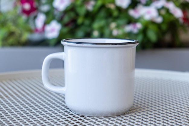 テーブルの上のコーヒー カップのモックアップは、緑の背景をぼかし