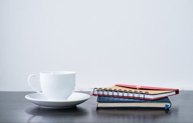 Coffee cup and notebook on desk