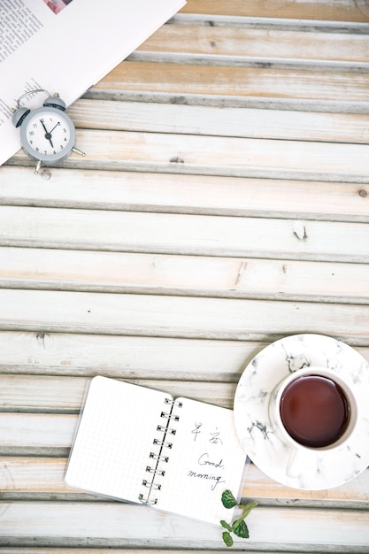 Coffee cup and notepad on white desktop