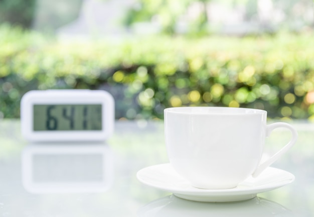 Coffee cup at office with digital clock