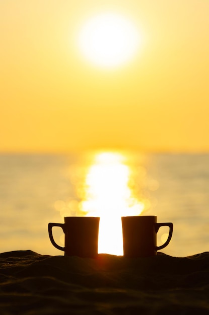 사진 해가 지는 동안 하늘을 배경으로 테이블 위에 있는 커피 컵