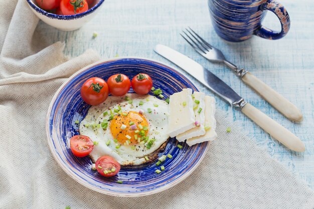 Tazza di caffè, un uovo, formaggio e pomodorini per una sana colazione.