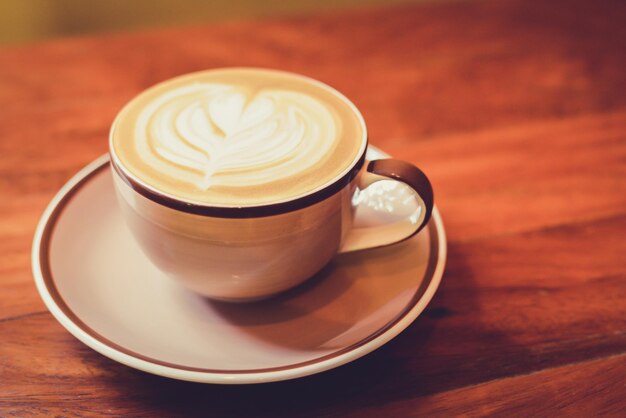 Coffee cup in plate on wooden table