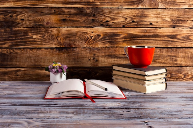 Coffee cup stack of books on a wooden table education concept