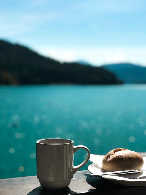Foto una tazza di caffè sul tavolo contro le montagne