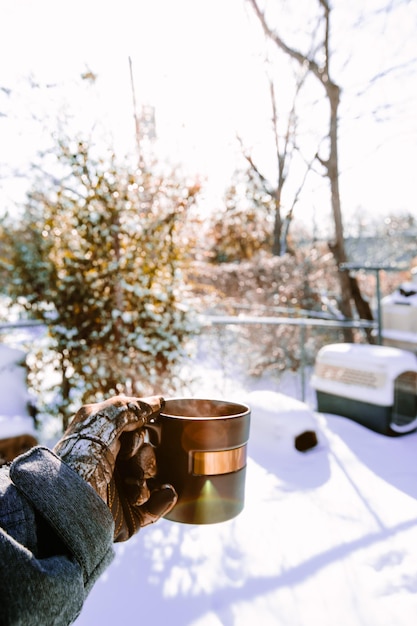 Coffee cup on table against trees